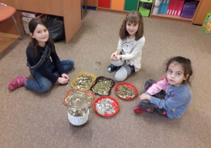 zdjęcie przedstawia dziewczynki z grupy 4 podczas segregacji monet zebranych w ramach akcji "Góra Grosza".